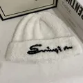 Primer plano de gorro de punto blanco con bordado negro en tela suave y gruesa - M / Blanco