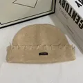 Vista de detalle del gorro de punto beige con etiqueta tejida y bordes deshilachados - M (56-58cm) / Caqui