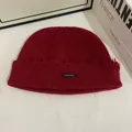 Detalle del gorro de punto burdeos con borde deshilachado y etiqueta de marca tejida - M (56-58cm) / Rojo