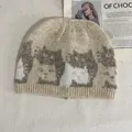 Detail of oat beige knit beanie featuring brown cat jacquard and ribbed cuff texture - M / Off White