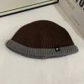 Close-up of a two-tone knit beanie with grey cuff and snowflake patch detail - M (56-58cm) / Coffee