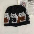 Detailed macro view of the knitted cat pattern and thick wool texture on this black beanie - M / Black