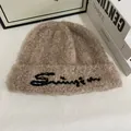 Primer plano de un gorro de punto de felpa marrón con bordado negro en fondo blanco - M / Caqui