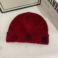 Detailed macro shot of distressed ripped edges on a dark red ribbed knit beanie hat - M / Red