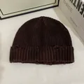 Close-up of dark coffee distressed knitted beanie featuring trendy ripped hole details - M / Coffee