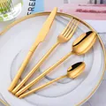 Detail of four-piece gold 304 stainless steel cutlery set on a white ceramic plate - Gold