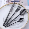 Premium 4-piece matte black 304 stainless steel cutlery set on a gold-rimmed plate - Black
