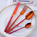 Rainbow iridescent stainless steel cutlery set with V-shaped handle on a white marble plate - Magic Red