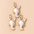 Macro-opname van goudkleurige kreeftbedeltjes met wit emaille voor DIY-sieraden - Wit