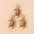 Macro shot of three golden sea turtle charms with leopard print enamel for DIY jewelry making - Brown Turtle