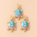 Macro view of blue enamel sea turtle charms with floral patterns and gold metal edges - Blue Turtle