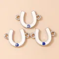 Macro shot of horseshoe-shaped white enamel charms with evil eye detail and connectors - Silver