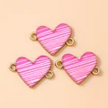 Detail van drie hartvormige bedels met roze strepen en goud voor het maken van sieraden - 10 Stuks/Verpakking / Goud Roze Rood
