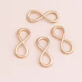 Polished gold infinity symbol charms for DIY jewelry making on soft pink background - Gold