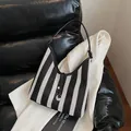 Minimalistische geweven okseltas met zwart-witte strepen, leren riem en stijlvolle kwast - 32cmx10cmx28cm / Zwart
