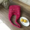Bolso playero de ganchillo hecho a mano rosa con forro sobre una mesa de madera - Rosa rojo