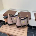 Borsa a tracolla trapuntata beige e nera in taglie medie e piccole su tavolo di legno - Grande / Kaki