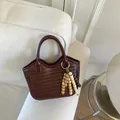 Bolso tipo cubo trenzado marrón con adorno de cuentas sobre fondo blanco puro - Rojo Vino Con Colgante de Cuentas de Madera