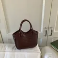 Deep burgundy woven leather bucket bag with arched top handles in a classic tote style - Wine Red Without Pendant