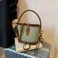 Saliegroene en donkerbruine emmertas met gouden draaisluiting en ronde bedel eraan - Groen met Hanger