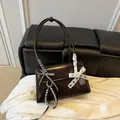 Dark brown glossy shoulder bag with lace bow charms and elegant top handle detail - With Pendant / Coffee