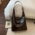 Minimalistische große braune Hobo-Tasche aus Leder mit breitem Schultergurt in Mattoptik - Braun