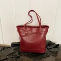 Elegante mochila de cuero rojo oscuro en un entorno minimalista con acabado mate - 39*14*30 / Rojo