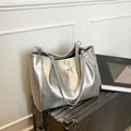 Sac fourre-tout argenté minimaliste avec nœud décoratif sur une valise noire - Argent