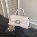 Macro detail of a pink handbag featuring a crystal-encrusted metal G-buckle closure - White