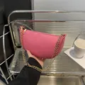 Rosa Halbmond-Tasche mit Litschistruktur und goldener Kette im Lifestyle-Szenario - Rosa