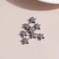 Close-up of star shaped alloy charms in antique silver finish for jewelry making - White K/Silver