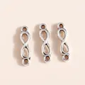 Macro shot of three antique silver infinity loop charms for DIY jewelry making - Silver