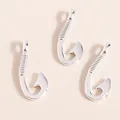 Close-up of three silver fish hook pendants with decorative textured metal details - Silver