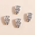 Detailed macro view of vintage silver owl alloy charms showing intricate embossed textures - Antique Silver