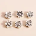 Detailed view of six vintage silver flower beads with intricate petal textures and holes - Antique Silver