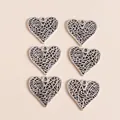 Detailed close-up of vintage silver alloy hollow heart charms with textured patterns - Antique Silver