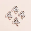 Macro detail of four silver-plated shamrock clover charms with vintage textured finish - Silver