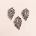 Detailed close-up of three vintage silver alloy hollow leaf charms for DIY jewelry making - Antique Silver