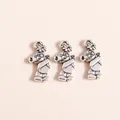 Detailed close-up of three silver-plated bear charms with intricate floral engravings - Antique Silver