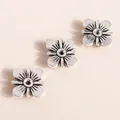 Detail of silver clover flower charms showing fine radial textures and matte alloy finish - Antique Silver