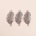 Macro detail of antique silver alloy feather charms with intricate carved textures - Antique Silver
