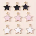 Detailweergave van negen kleurrijke emaille sterrenhangers met gouden randen voor DIY-sieraden - Meerkleurig