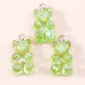 Close-up of translucent light green resin gummy bear charms with sparkly sequins - Green