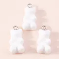 Macro detail of three white resin gummy bear charms with silver metal rings for DIY - White