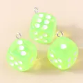 Vue détaillée de trois breloques dés en acrylique vert translucide avec anneaux argent - Vert clair