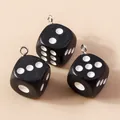 Détail de trois breloques dés en résine noire mate avec anneaux argentés pour bijoux DIY - Noir