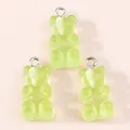 Close-up of translucent light green resin gummy bear charms with silver metal rings - Green