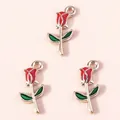 Three red enamel rose charms with gold alloy base and green leaves on pink background - Red
