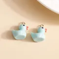 Detail van twee lichtblauwe hars eend hangers met metalen ringen voor DIY sieraden maken - 10 Stuks/Verpakking / Meerblauw