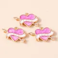 Dettaglio di ciondoli a cuore in smalto rosa con bordo dorato e nastro Love bianco - Viola